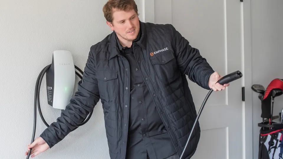 Energy Solutions electrician holding the plug of a home EV charger