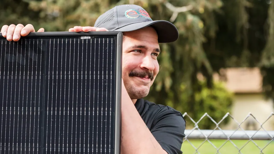 Energy Solutions installer carrying a solar panel