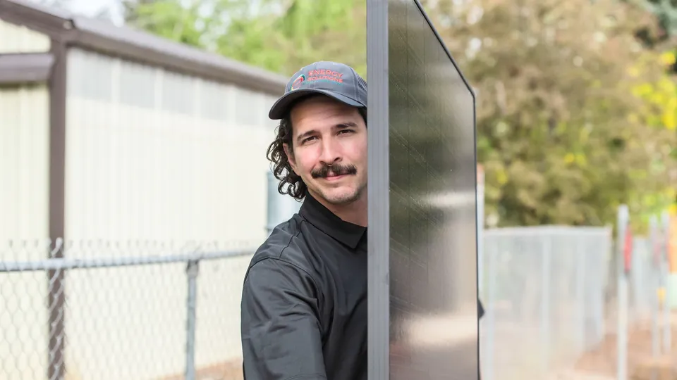 Energy Solutions installer carrying a solar panel