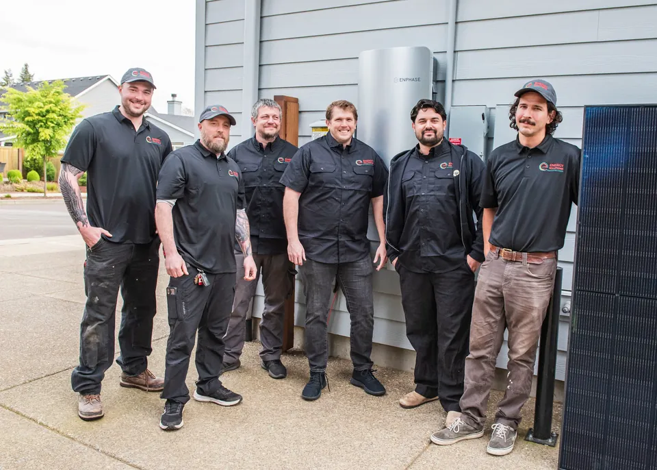 Six members of the Energy Solutions crew beside a customer home