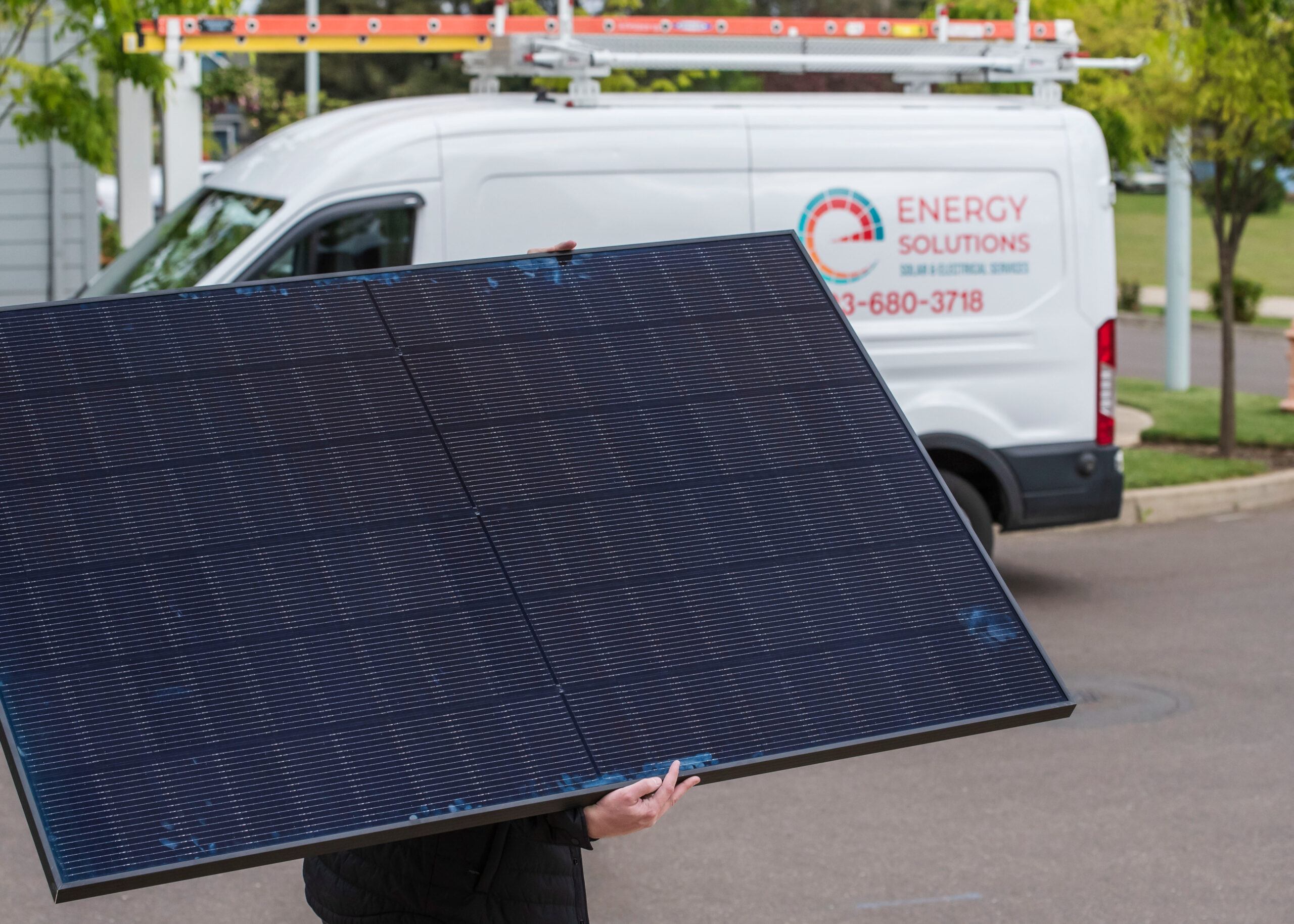 Energy Solutions LLC service van and technician managing premium solar panels for new installations and system maintenance repairs.