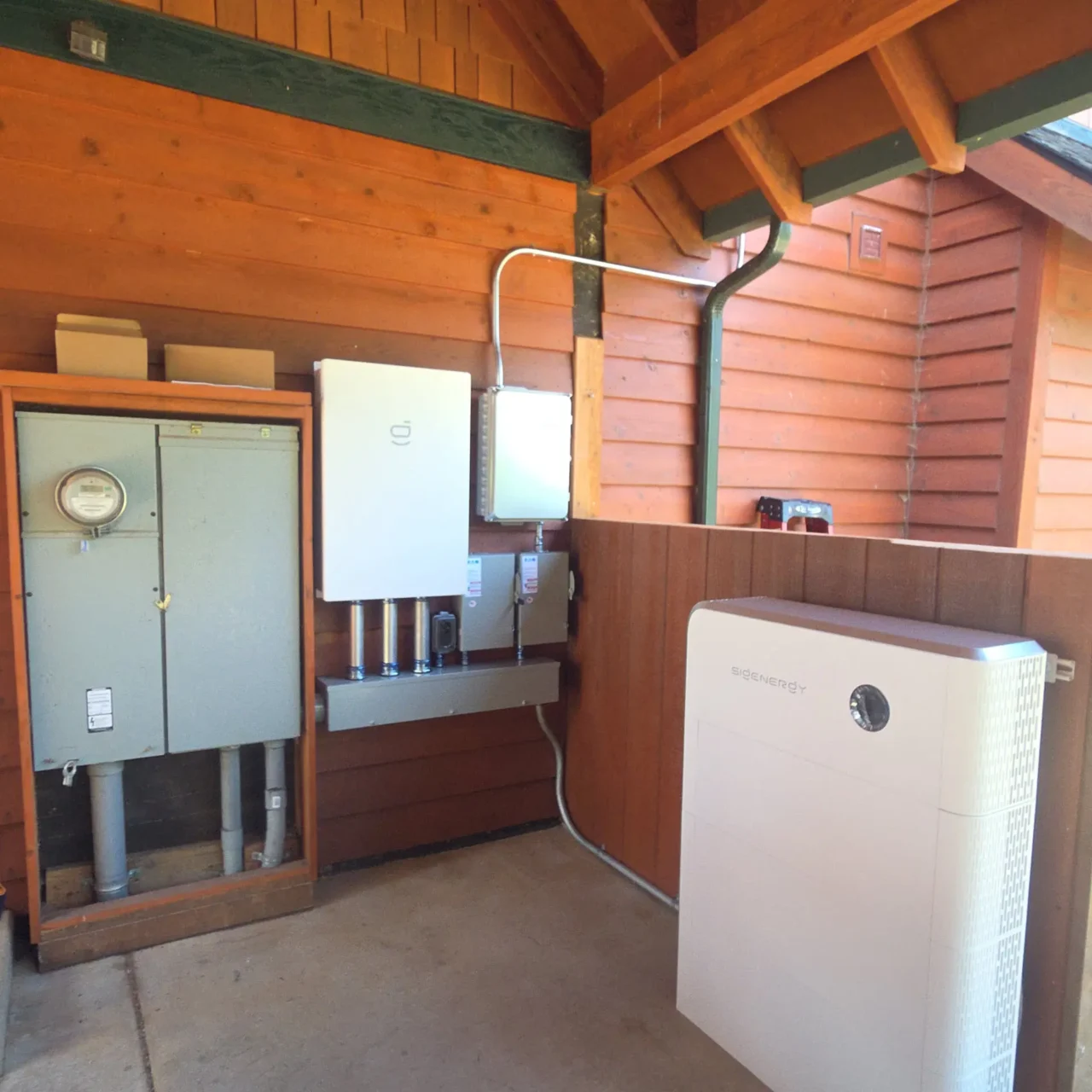Solar battery system in wood-paneled utility shed.