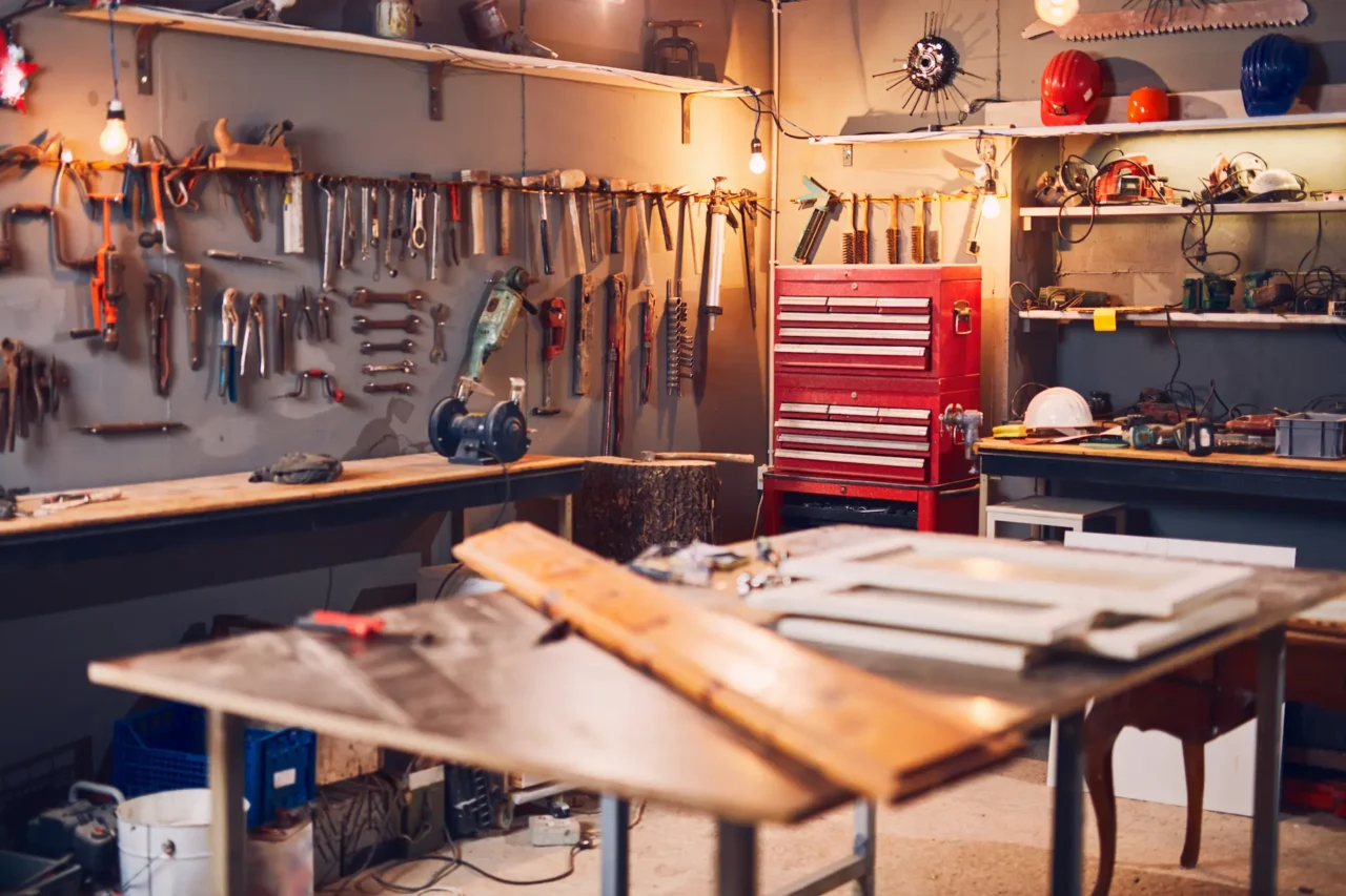Workshop with tools on wall, red toolbox, workbenches.